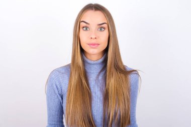 Stüdyoda poz veren şaşırmış yüzlü genç bir kadın.