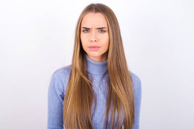 Sinirli yüz ifadesi olan genç bir kadın.