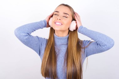 Kulaklık takan, gözleri kapalı genç bir kadın.