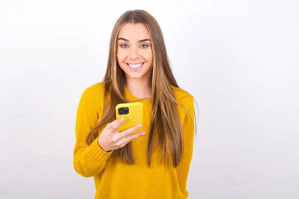Νεαρή Γυναίκα Ποζάρει Smartphone Στο Στούντιο Και Χαμογελά — Φωτογραφία Αρχείου