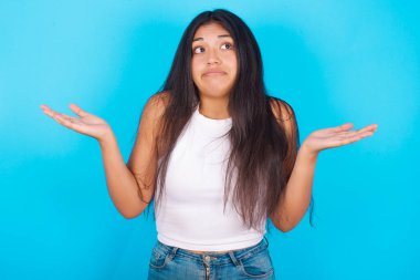 Belki evet ya da hayır. Mavi arka planda beyaz kolsuz bluz giyen şüpheli genç bir kız şaşkınlık içinde omuz silkiyor ve ne istediğine karar vermeye çalışıyor. Tereddüt ve belirsizlik.