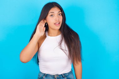 - Aman Tanrım! Mavi arka planda beyaz kolsuz bluz giyen, ağzı açık, eli kulağında, dedikoduları dinlemeye çalışan komik, şaşkın, genç İspanyol kız..