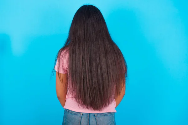 Young Hispanic Girl Wearing Pink Shirt Blue Background Standing Backwards — 图库照片