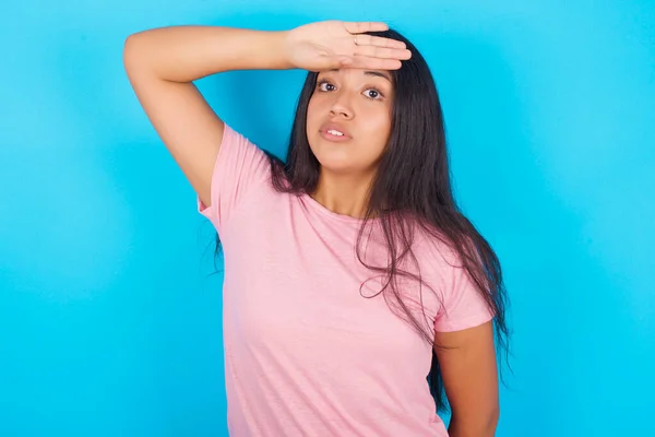 Mladá Hispánka Růžovém Tričku Modrém Pozadí Která Rukou Otírá Čelo — Stock fotografie