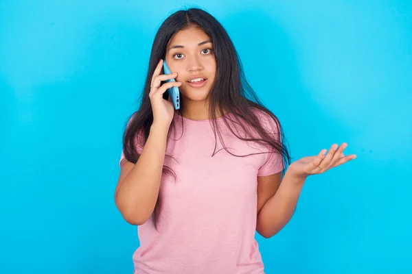 Young Hispanic Girl Wearing Pink Shirt Blue Background Talking Phone — Fotografia de Stock