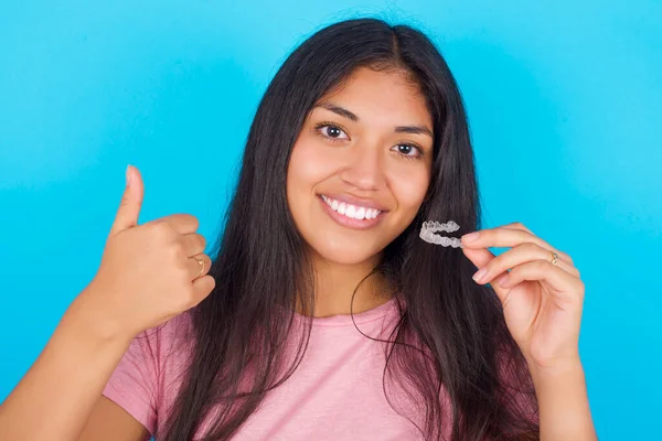 Young Hispanic Girl Wearing Pink Shirt Blue Background Holding Invisible — Fotografia de Stock