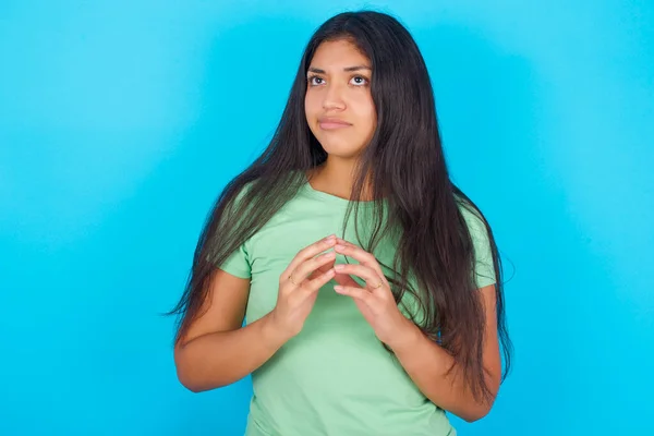 Young Hispanic Girl Wearing Green Shirt Blue Background Steepls Fingers — Foto Stock