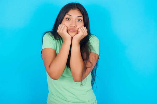 Mavi Arka Planda Yeşil Tişört Giyen Genç Spanyol Kız Şaşırmış — Stok fotoğraf