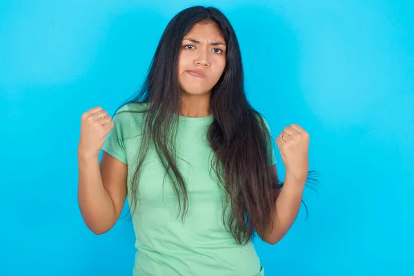 Irritated Young Hispanic Girl Wearing Green Shirt Blue Background Blows — Stock Photo, Image