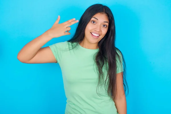 Mavi Arka Planda Yeşil Tişört Giyen Genç Spanyol Kız Şakakta — Stok fotoğraf