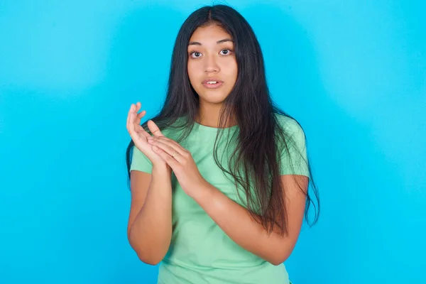 Surpreendida Emocional Jovem Hispânica Vestindo Camiseta Verde Sobre Fundo Azul — Fotografia de Stock