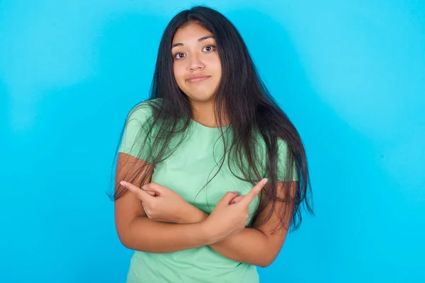 Menina Hispânica Jovem Vestindo Camiseta Verde Sobre Fundo Azul Cruza — Fotografia de Stock