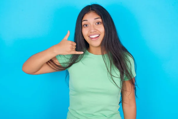 Young Hispanic Girl Wearing Green Shirt Blue Background Makes Phone — Fotografia de Stock