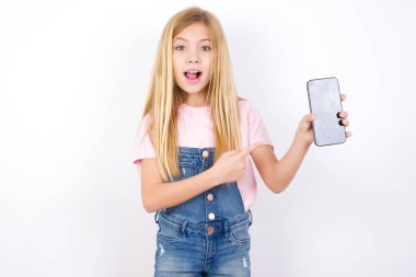 Çekici, neşeli, beyaz kot pantolon giyen beyaz bir kız. El ele tutuşmuş, siyah ekranı gösteriyor.