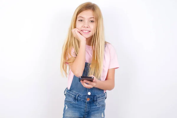 Radosna Piękna Kaukaska Dziewczynka Dżinsach Białym Tle Pozuje Telefonem Komórkowym — Zdjęcie stockowe