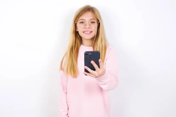 Hermosa Niña Caucásica Con Suéter Rosa Sobre Fondo Blanco Sostiene —  Fotos de Stock