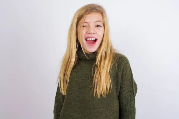 Menina Branca Usando Camisola Malha Verde Contra Fundo Branco Piscando — Fotografia de Stock