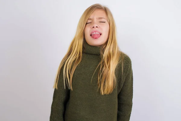 Kaukasisches Mädchen Grünem Strickpullover Vor Weißem Hintergrund Streckt Die Zunge — Stockfoto