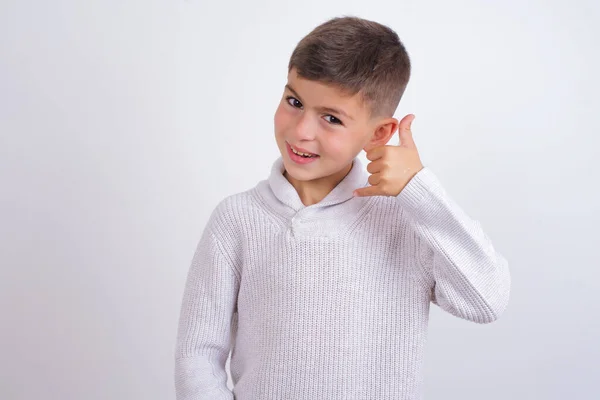 Beyaz Arka Planda Dikilmiş Örülü Süveter Giyen Beyaz Çocuk Telefonla — Stok fotoğraf