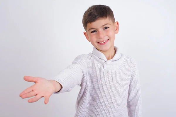 Beyaz Arka Planda Dikilmiş Örgü Kazak Giyen Beyaz Çocuk Selamlama — Stok fotoğraf