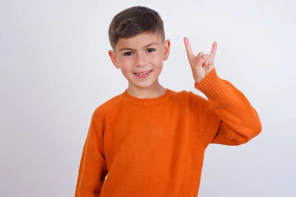 Vit Pojke Klädd Stickad Orange Tröja Står Över Vit Bakgrund — Stockfoto