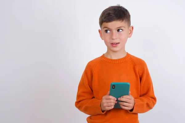 Niño Caucásico Usando Suéter Naranja Punto Pie Sobre Fondo Blanco —  Fotos de Stock