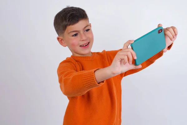 Niño Caucásico Usando Suéter Naranja Punto Pie Sobre Fondo Blanco —  Fotos de Stock