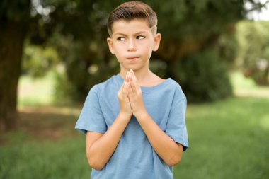 Çekici, güzel, beyaz, mavi tişörtlü çocuk dışarıda dikilip el ele tutuşarak bir fikir üretiyor. Bana bak.