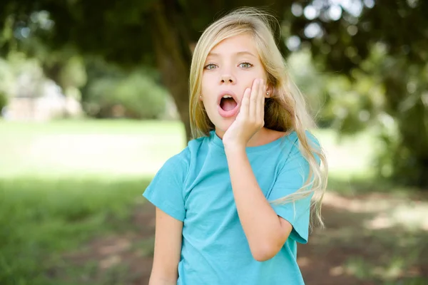 Shocked Caucasian Little Kid Girl Wearing Blue Shirt Standing Outdoors — Stock Photo, Image