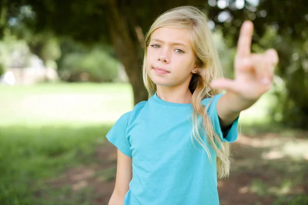 Маленькая Белая Девочка Голубой Футболке Стоит Улице Высмеивает Людей Пальцами — стоковое фото