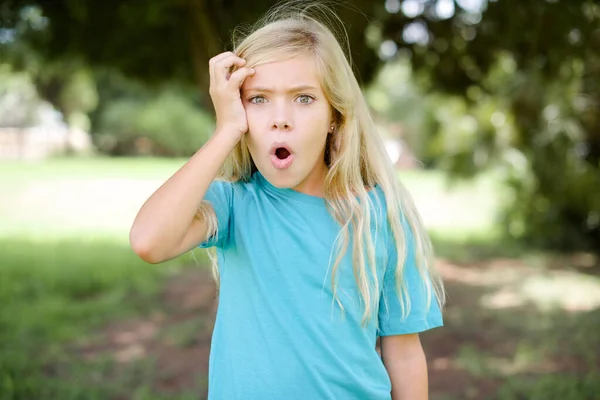 Embarrassed Caucasian Little Kid Girl Wearing Blue Shirt Standing Outdoors — Stock Photo, Image