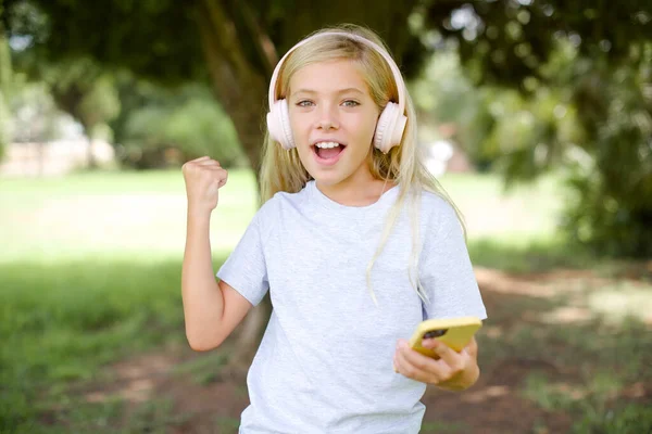 Positieve Blanke Kleine Meisje Dragen Witte Shirt Buiten Staat Houdt — Stockfoto