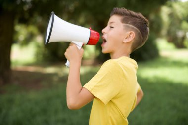 Açık havada duran sarı tişört giyen komik, güzel, beyaz çocuk. İnsanlar içten duygular besliyor. Kopyalama alanı oluşturun. Megafonla bağırıyordu..