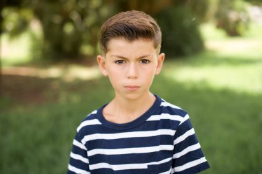 Sersemlemiş, beyaz, çizgili tişört giyen çocuk şok edici haberlere tepki veriyor. Şaşırmış Model nefesini tutuyor