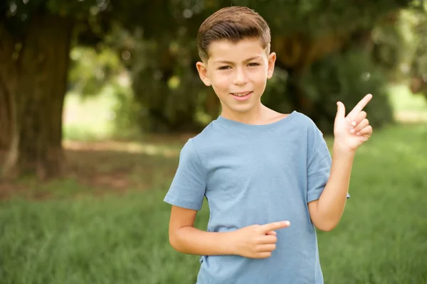 Sorrindo Lindo Garoto Caucasiano Vestindo Camiseta Azul Livre Indicando Espaço — Fotografia de Stock