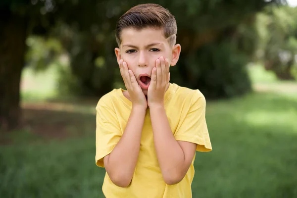 恐怖の美しい白人の小さな男の子黄色のTシャツを着て屋外に立ってショップでの価格でショックを受けました 人々と人間の感情の概念 — ストック写真