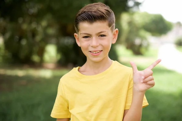 아름다운 캅카스 아이가 티셔츠를 밖에서 수화로 손가락을 가리키며 — 스톡 사진