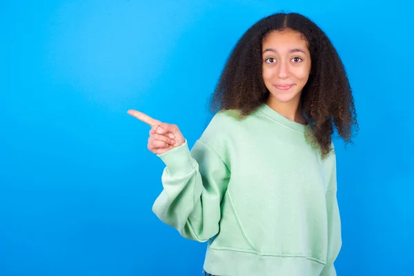 Pozytywna Piękna Nastolatka Zielonym Swetrze Stojąca Niebieskim Tle Zadowolonym Wyrazem — Zdjęcie stockowe