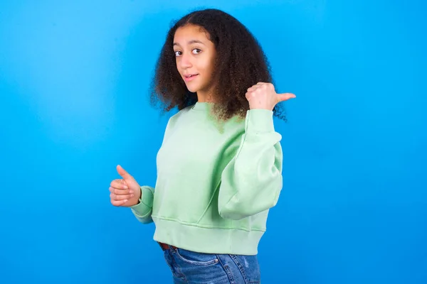 Impressionné Belle Adolescente Portant Pull Vert Debout Sur Fond Bleu — Photo