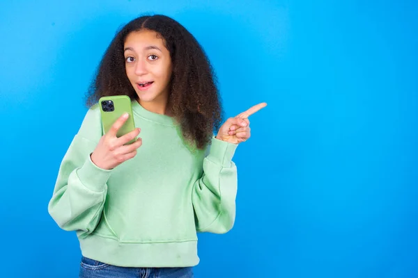 Sorprendida Hermosa Adolescente Con Suéter Verde Pie Sobre Fondo Azul — Foto de Stock