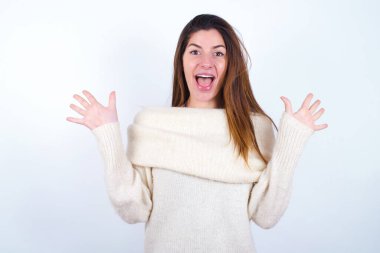 İyimser genç bir kadın beyaz süveter giyerek sevinçten havalara uçuyor, birinden müthiş bir hediye aldığı için mutlu, yüksek sesle bağırıyor, heyecanlı bir manken gibi çığlık atıyor..