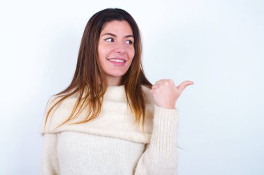 Beyaz süveter giyen, fotokopi odasına bakan, reklamları olan çekici genç bir kadın.