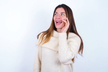 Beyaz arka plan giyen genç bir kadın inanılmaz özel haberler duyuyor çığlık paylaşımı