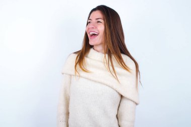 Beyaz süveter giyen genç bir kadın. Yeni planlar için çok mutlu ve heyecanlı..