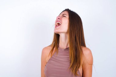 Spor kıyafetleri giyen genç bir kadın kızgın ve öfkeli çığlık atıyor ve öfkeyle bağırıyor. Öfke ve agresif kavram.