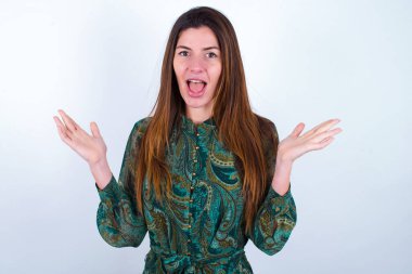 Çiçekli elbise giyen, dehşete düşmüş genç bir kadın. Belirsizlikle beyaz arka plan jestleri, kameraya bakıyor. Şaşırtıcı soruya cevap veremediği için kafası karışık.