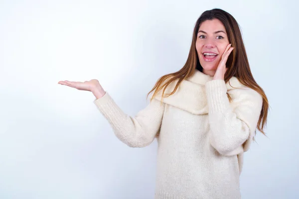 クレイジー若い女性身に着けている白いセーター白い背景アドバイス割引価格ホールドオープンパーム新製品 — ストック写真