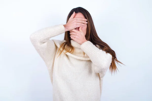 年轻女子身穿白色毛衣 用手捂住眼睛和嘴 感到惊讶和震惊 隐藏感情 — 图库照片