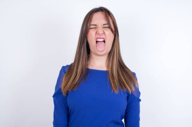 Vücut dili. Stresli genç Arap kadın beyaz sırt çantasına mavi elbise giymiş, kaşlarını çatmış, bir şeyden tiksindiğini gösteriyor..