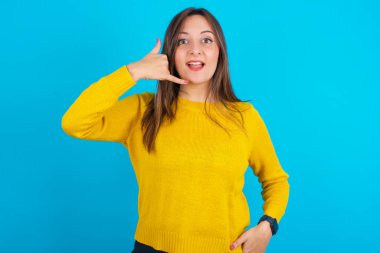 Mavi sırt çantasına sarı örülü süveter giyen genç Arap kadın telefon hareketinde bulunuyor, beni tekrar ara diyor, mutlu bir ifadesi var..